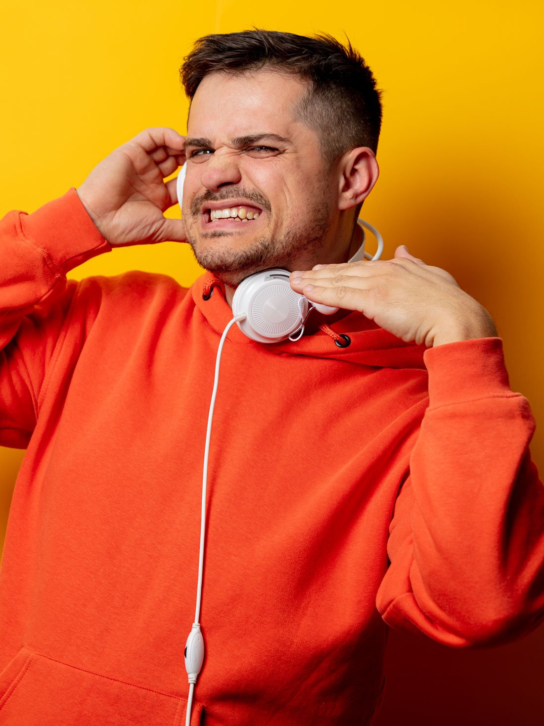 displeased-man-with-headphones-on-yellow-backgroun-2022-01-11-01-51-52-utc.jpg